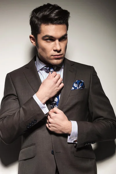 Young business man fixing his tie — Stock Photo, Image