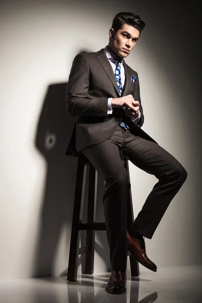 Geschäftsmann schaut weg, während er auf einem Hocker sitzt — Stockfoto