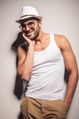 Mutlu genç casual adam beyaz duvara yaslanmış