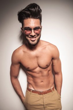 Gülümseyen genç casual adam gömleksiz poz 