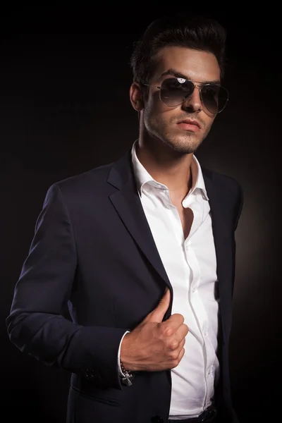Elegante jovem homem de negócios arrumando seu casaco — Fotografia de Stock