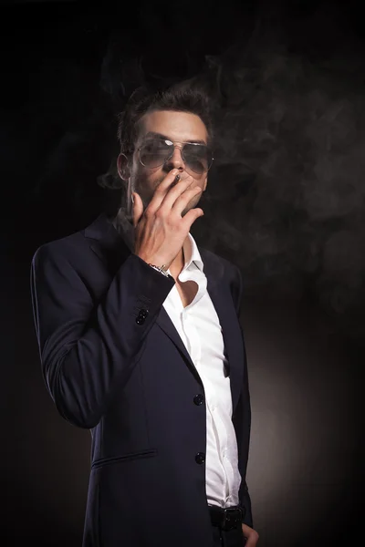 Привлекательный молодой бизнесмен, курящий сигареты — стоковое фото