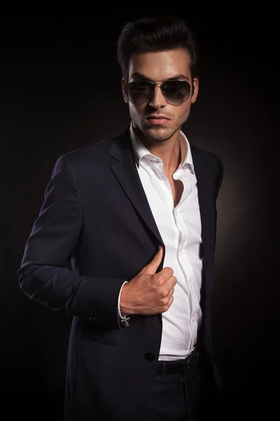 Homem de negócios elegante posando no fundo do estúdio preto — Fotografia de Stock