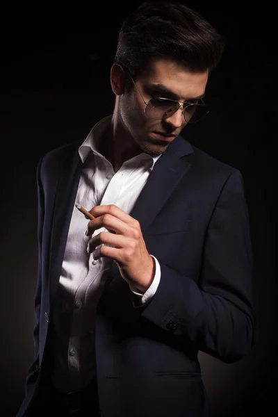 Elegante hombre de negocios sosteniendo un cigarrillo en su mano izquierda . — Foto de Stock