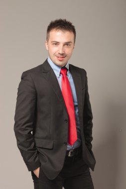 Ellerini ceplerine tutan yakışıklı genç iş adamı.