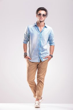 Yakışıklı genç casual adam gri arka plan üzerinde poz 