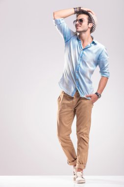 adam elini ararken şapkasını tutarak