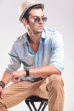 Bir taburede oturan çekici moda adam