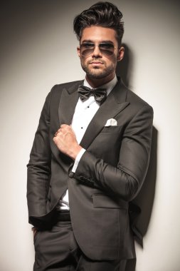 Genç yakışıklı iş adamı duvara yaslanmış 