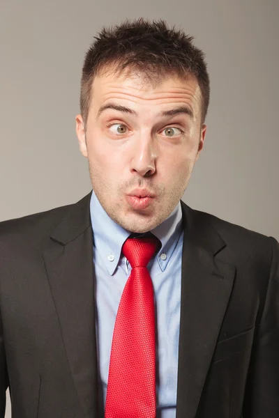 Joven hombre de negocios haciendo una cara divertida — Foto de Stock