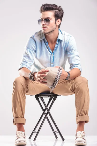 Young casual fashion man looking away while sitting — Stock Photo, Image