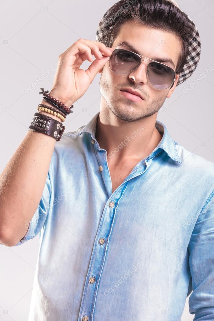Casual fashion man taking off his sunglasses