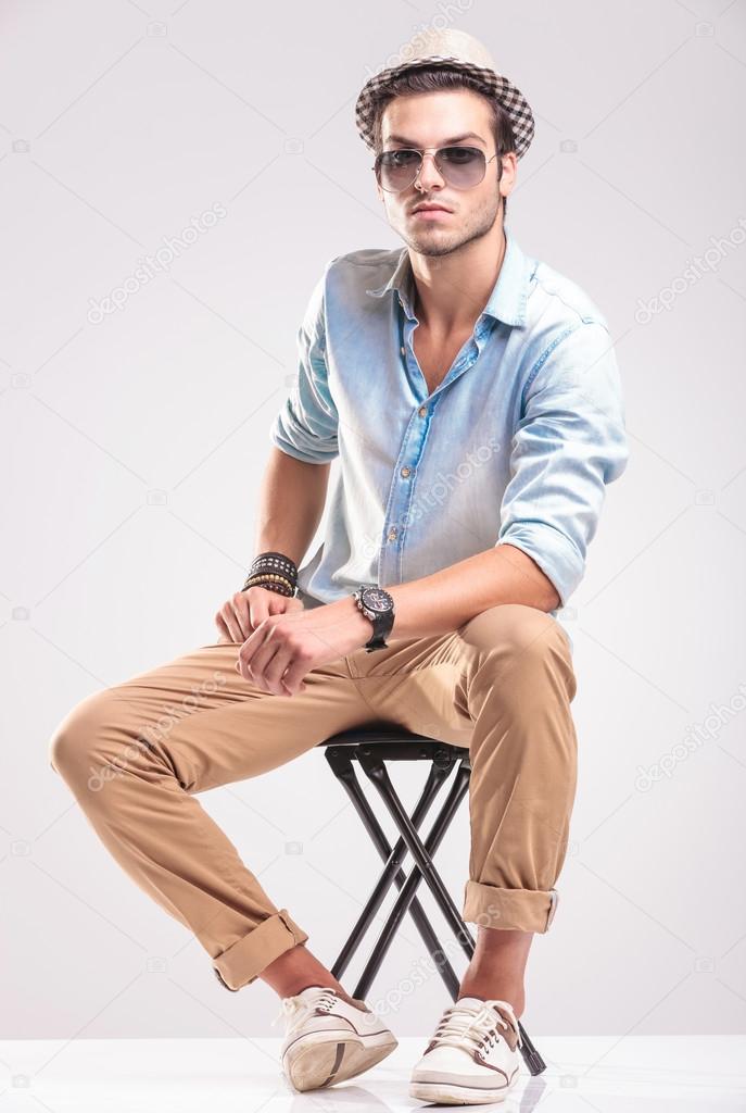 Fashion man sitting resting his hands on his leg