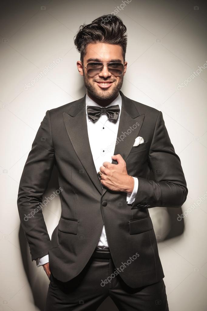 young business man smiling while fixing his jacket