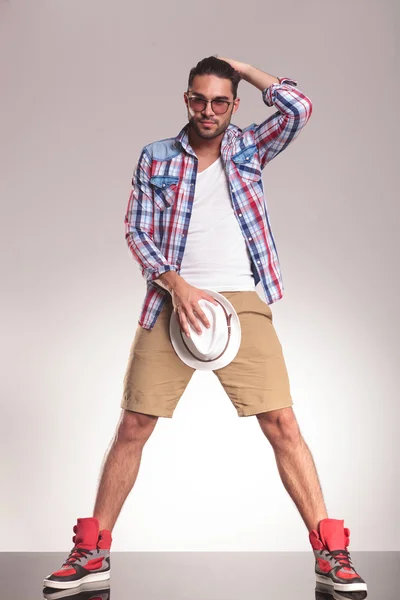 Casual youn man holding his hat to his crotch — Stock Photo, Image