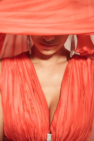 Elegante junge Frau verhüllt ihre Augen mit einem roten Schal. — Stockfoto