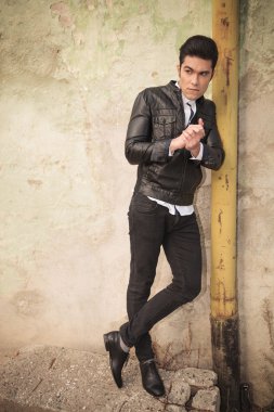 Eski bir boruya eğilerek rahat moda adam