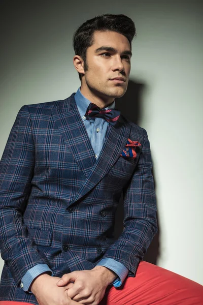 Handsome young man leaning on a grey wall — Stock Photo, Image