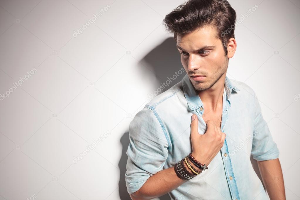 handsome man pulling his shirt while looking down.
