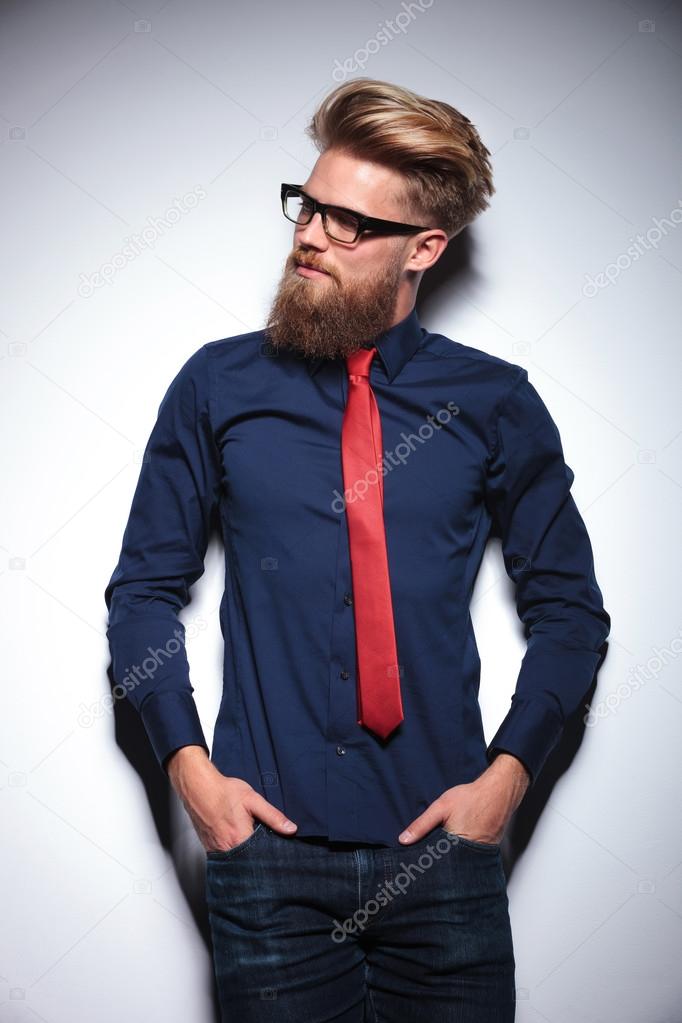 Handsome young business man leaning on a white wall