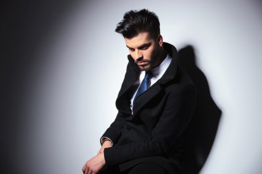 iş adamı bir taburede oturan süre aşağı bakıyor.