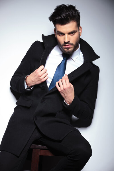 Молодой бизнесмен сидит на стуле
 