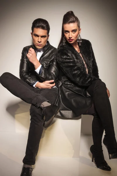 Fashion woman sitting on table next to her boyfriend — Stock Photo, Image