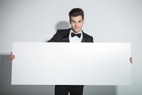 Business man holding a big white board — Stock Photo, Image