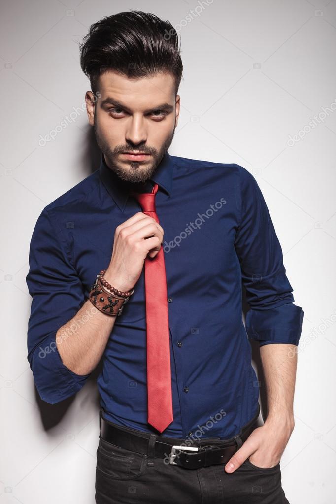 Handsome young business man pulling his tie