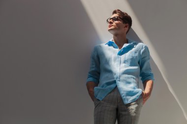 Genç casual adam gri bir duvara yaslanmış 
