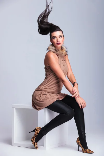 Sexy fashion woman sitting on a white table — Stock Photo, Image