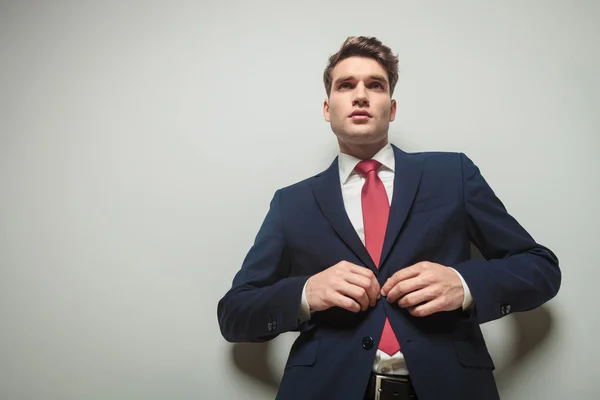 Junger attraktiver Geschäftsmann schließt seine Jacke — Stockfoto