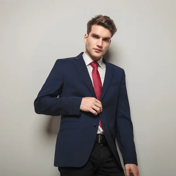 Joven hombre de negocios guapo cerrando su chaqueta — Foto de Stock