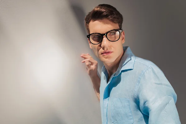 Joven hombre casual apoyando su mano en la pared — Foto de Stock