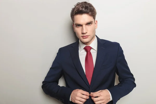 Handsome young business man closing his jacket — Stock Photo, Image
