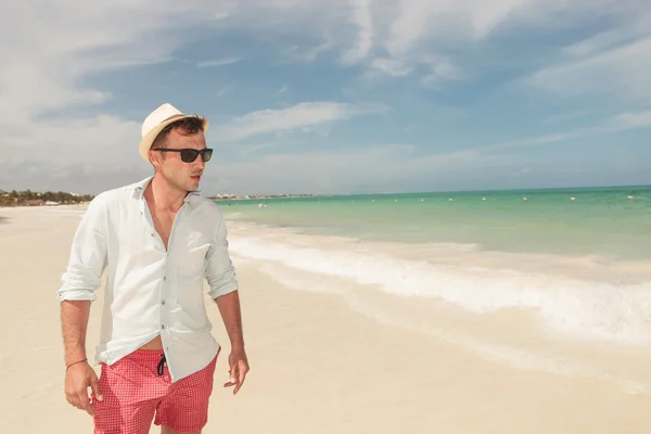 Schöner junger Mann geht am Strand spazieren, — Stockfoto