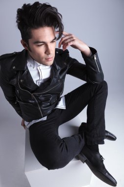 Oturan bir genç moda adam görünümünü