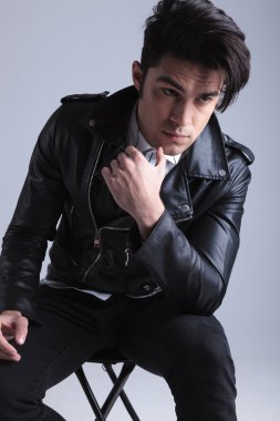 bir taburede oturan genç moda adam