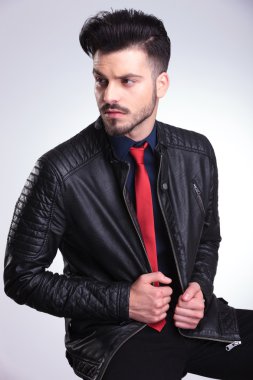Ceketini çekerek bir sandalyede oturan iş adamı.