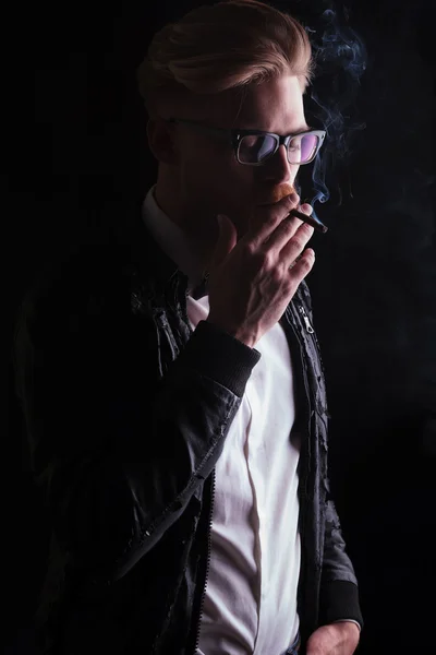 Fiatal üzletember élvezi a cigaret bőr kabátot visel — Stock Fotó