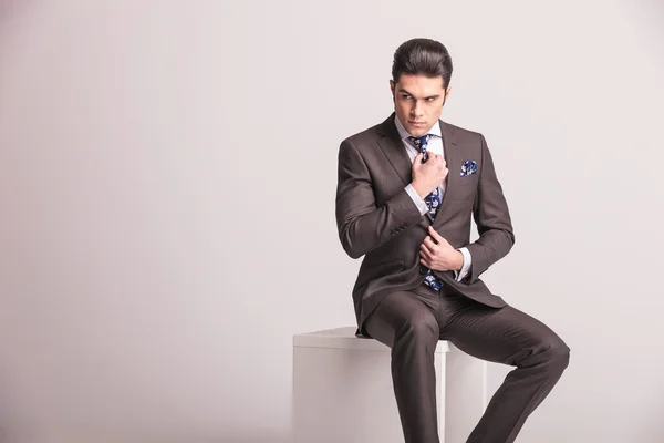 Привлекательный молодой бизнесмен чинит галстук — стоковое фото