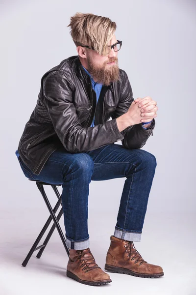 Hipster-Mann hält im Sitzen die Hände zusammen — Stockfoto