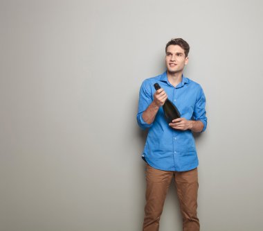 Genç adam gri bir duvara yakın poz 