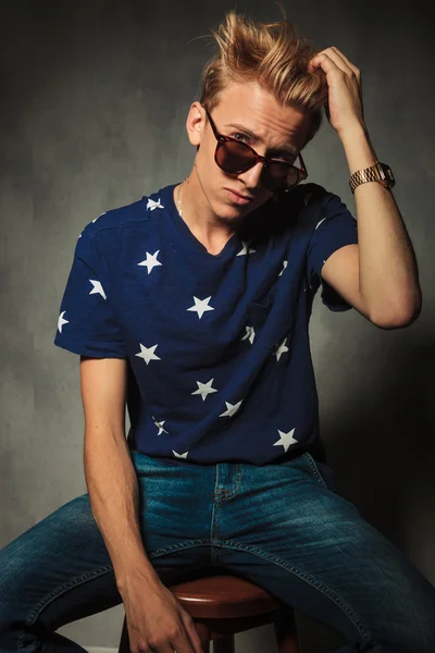 Fashion portrait of a cool young man fixing his hair — Stock Photo, Image