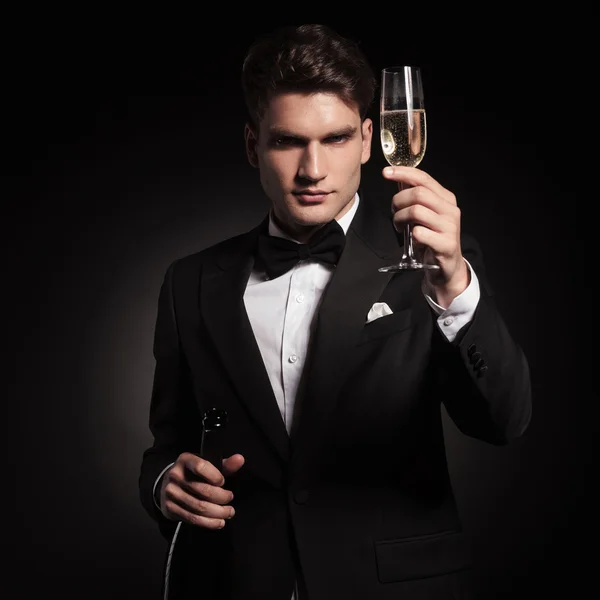 Eleganter Mann hält ein Glas Champagner in der Hand. — Stockfoto