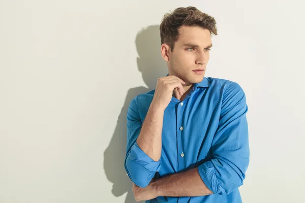 Pensive young man leaning on a wall — Stock Photo, Image