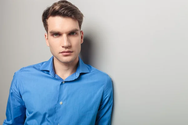 Casual man leaning on a grey wall — Stock Photo, Image