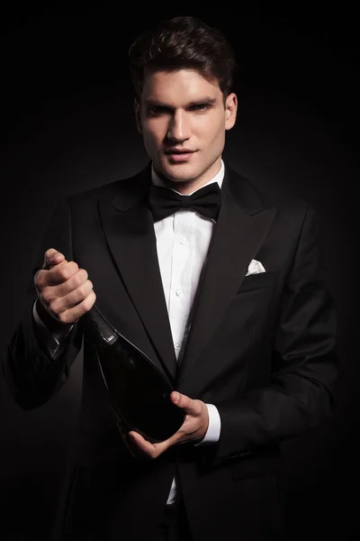 Jeune homme élégant tenant une bouteille de vin — Photo