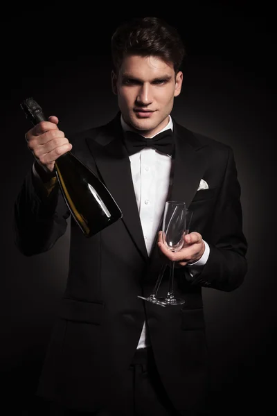 Bir şişe şarap tutan zarif yakışıklı adam — Stok fotoğraf