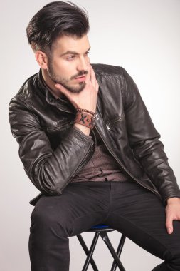 bir taburede oturan genç moda adam